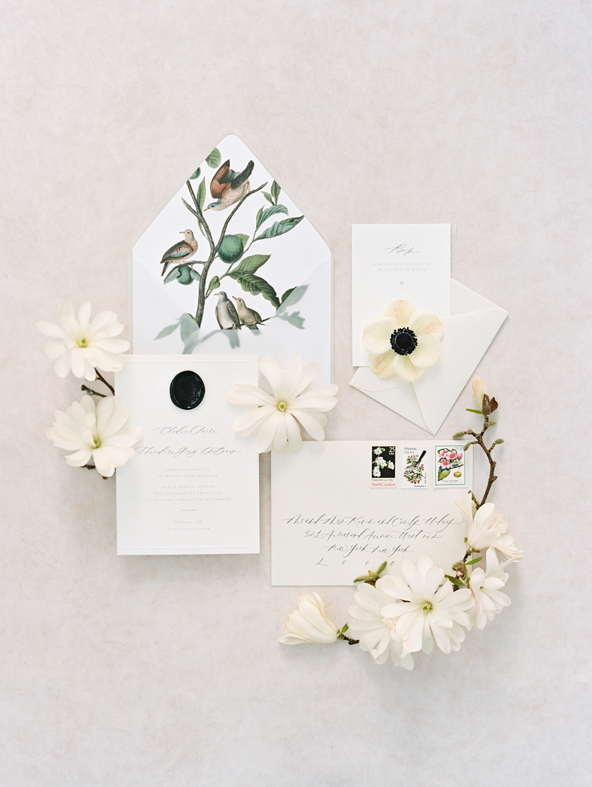 Wedding invitation with anenomes and tulip magnolias on a white background
