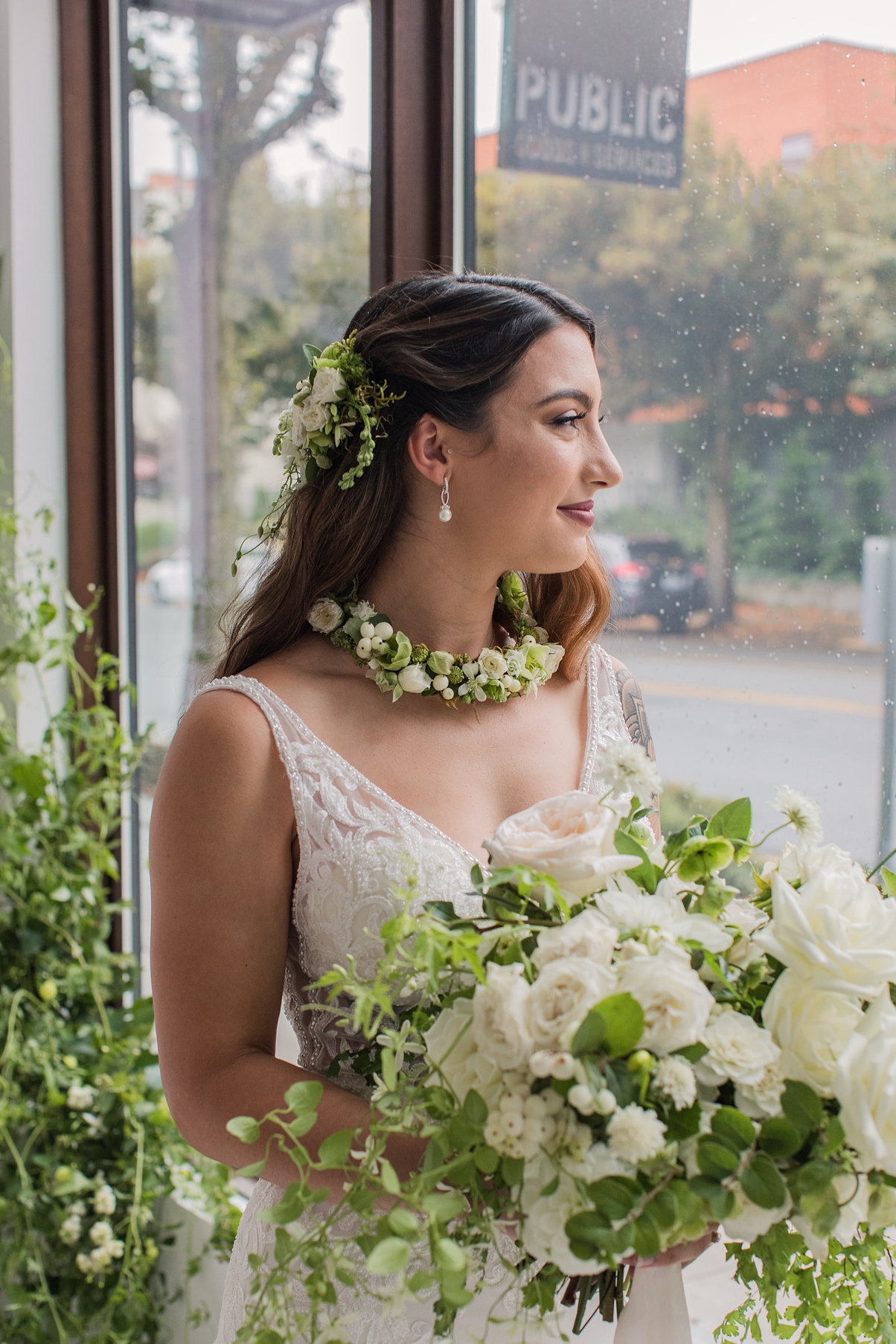 Bride holding white bouquet and looking out window