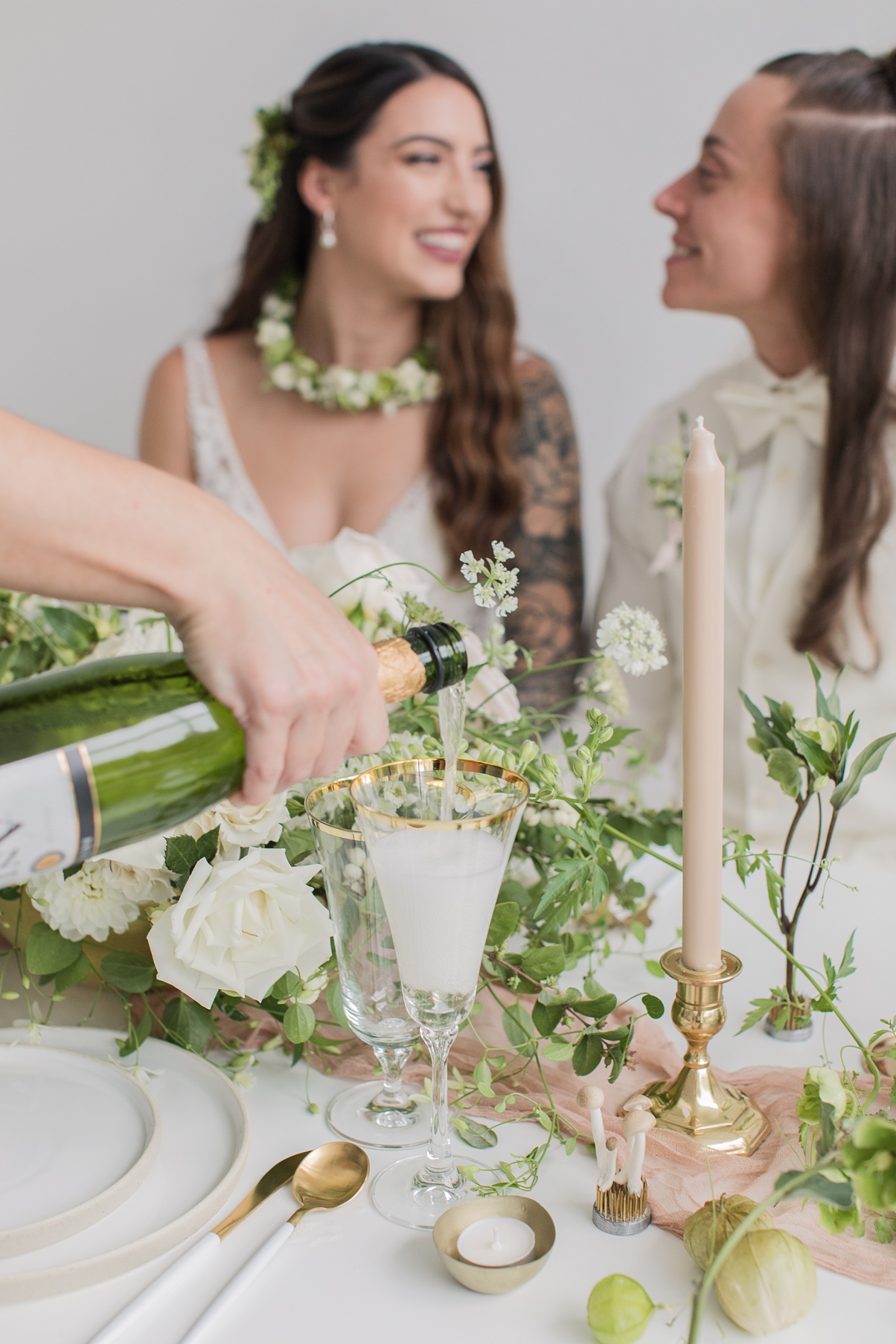 Champagne being poured as brides look at each other lovingly