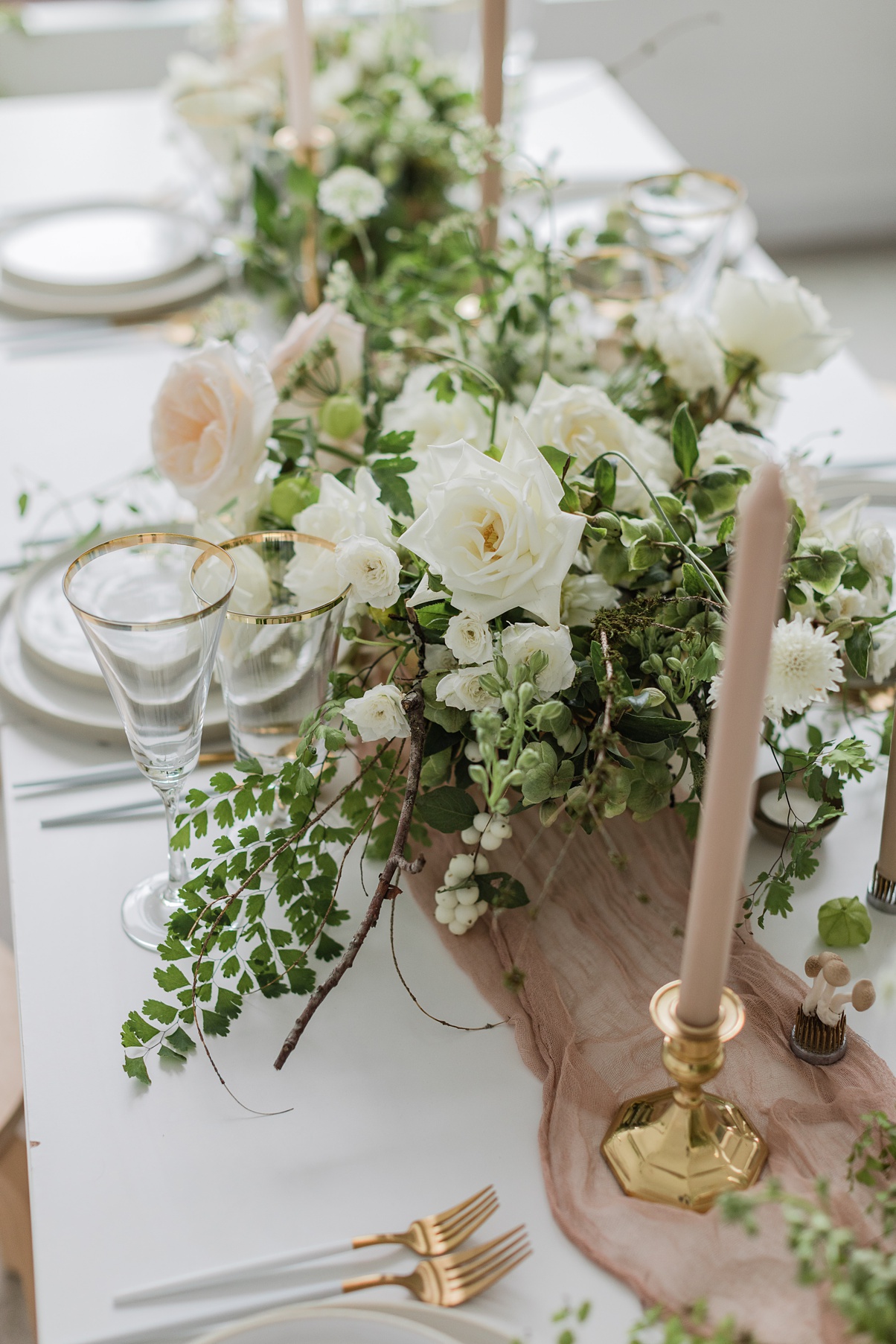 A floral centerpiece with maidenhair fern and roses
