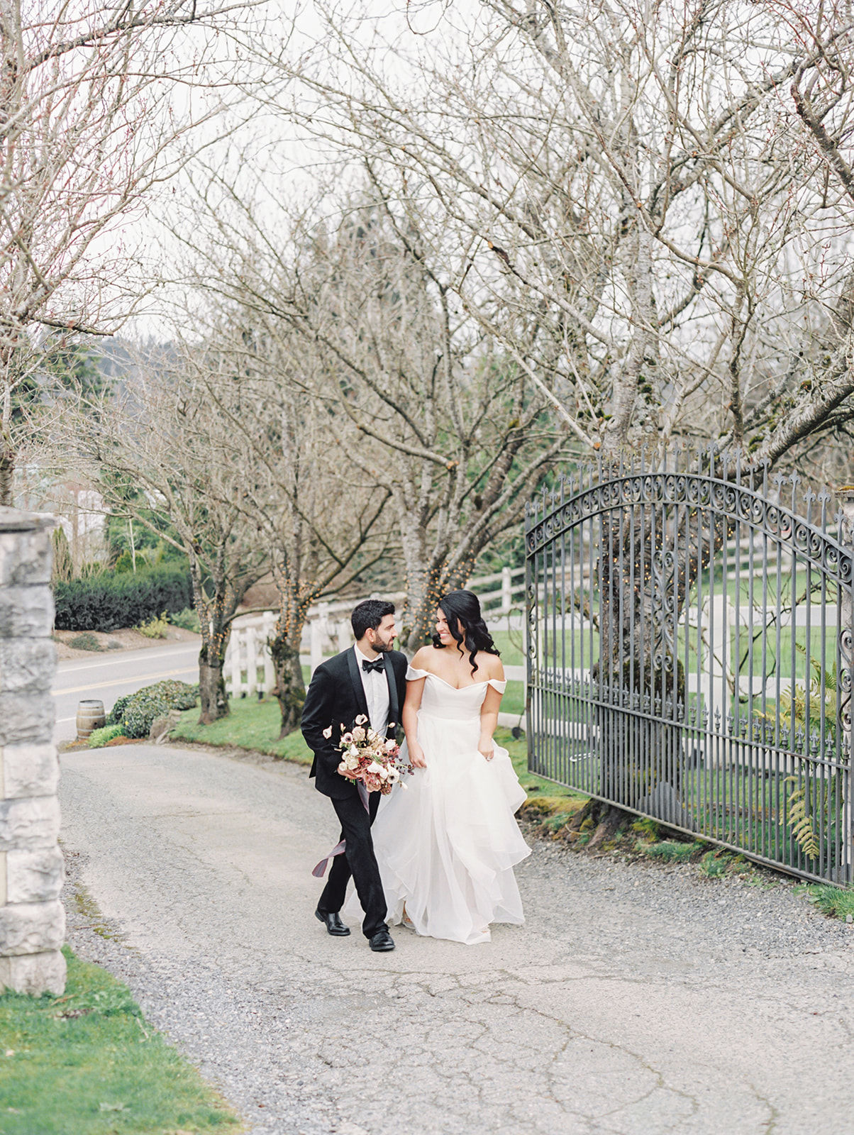 A couple walking up the entrance gate to Chateau Lill for their wedding