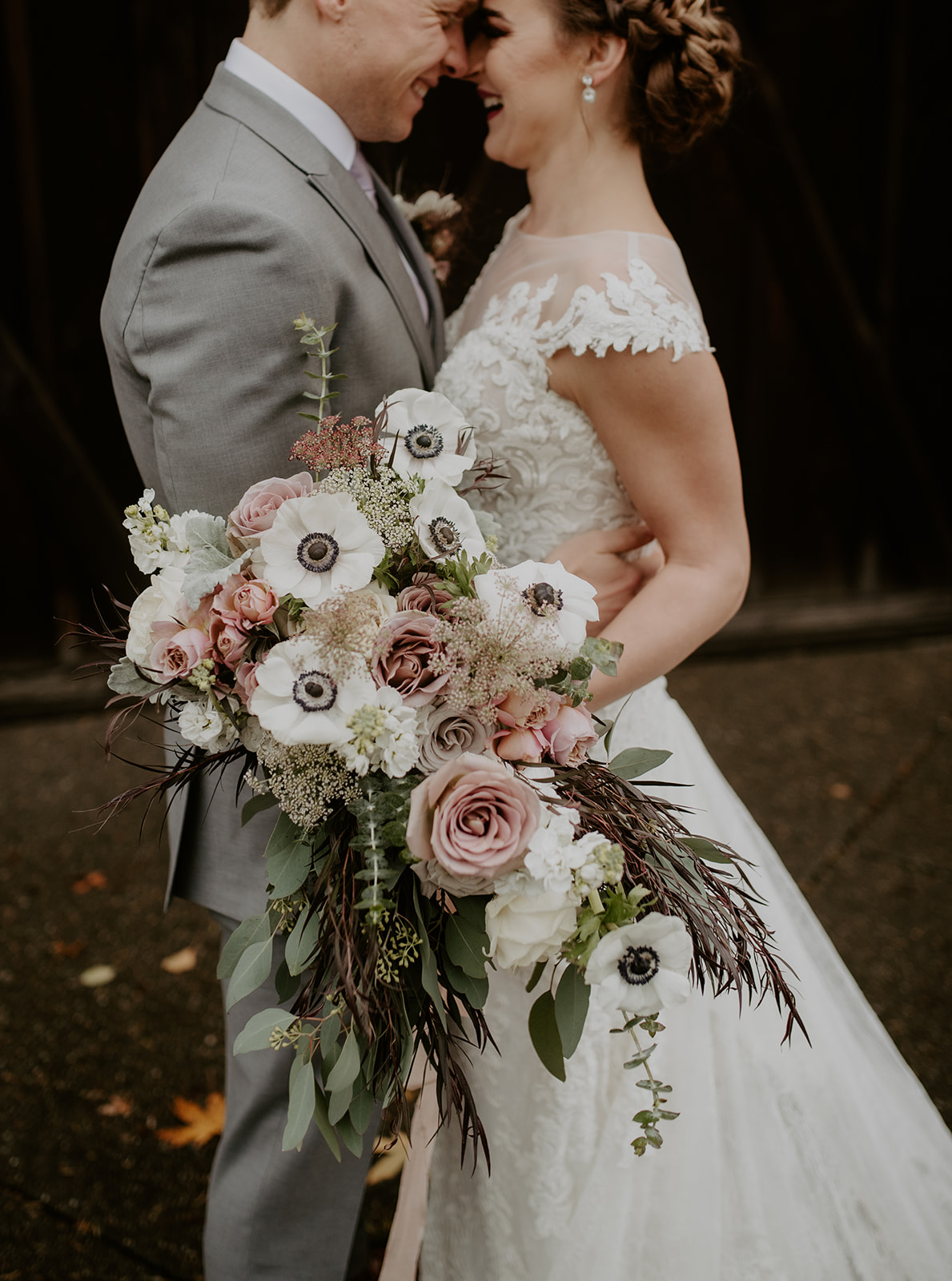 A couple embracing and holding a wedding bouquet