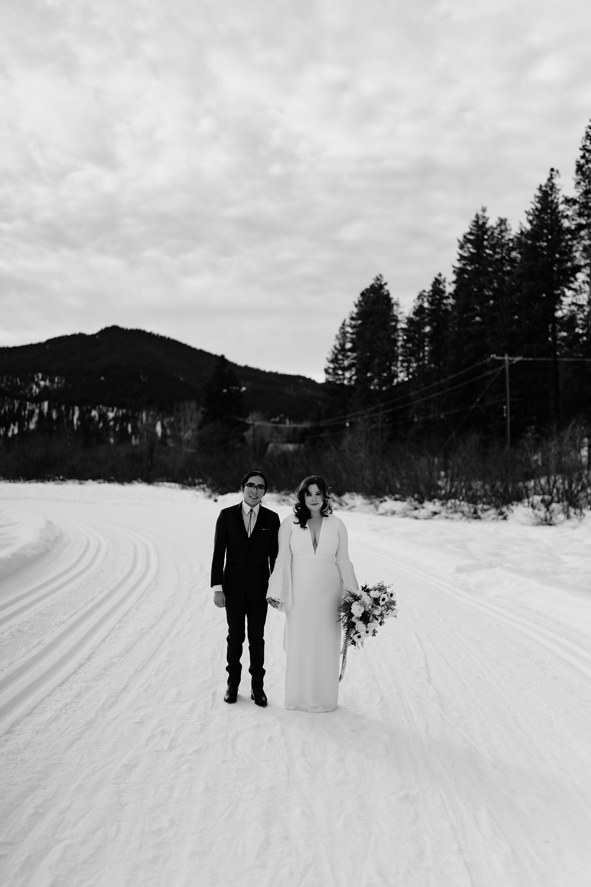 The couple holding hands in the snow, in a black and white image
