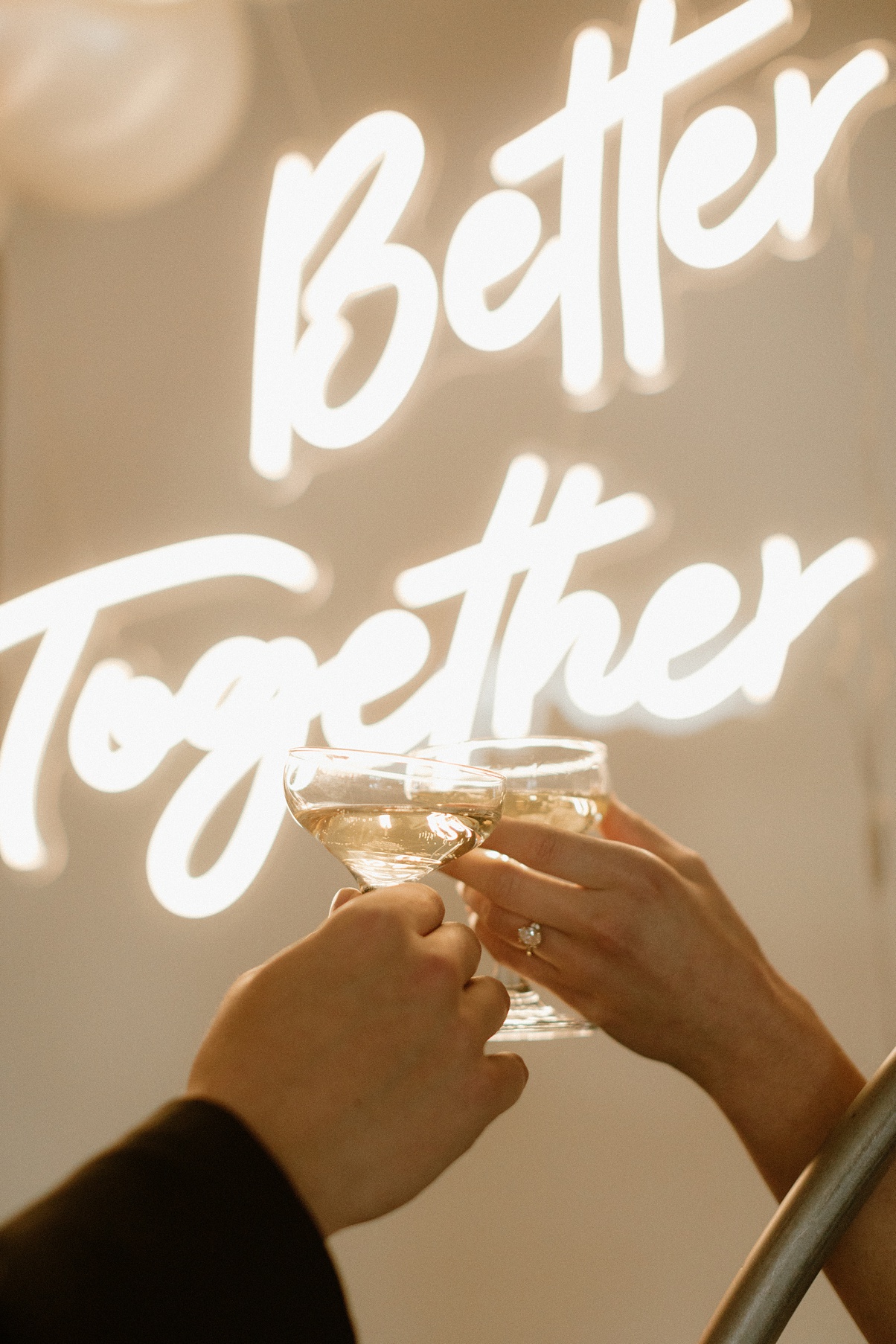 Block 41 wedding neon sign that says "better together" with a champagne toast