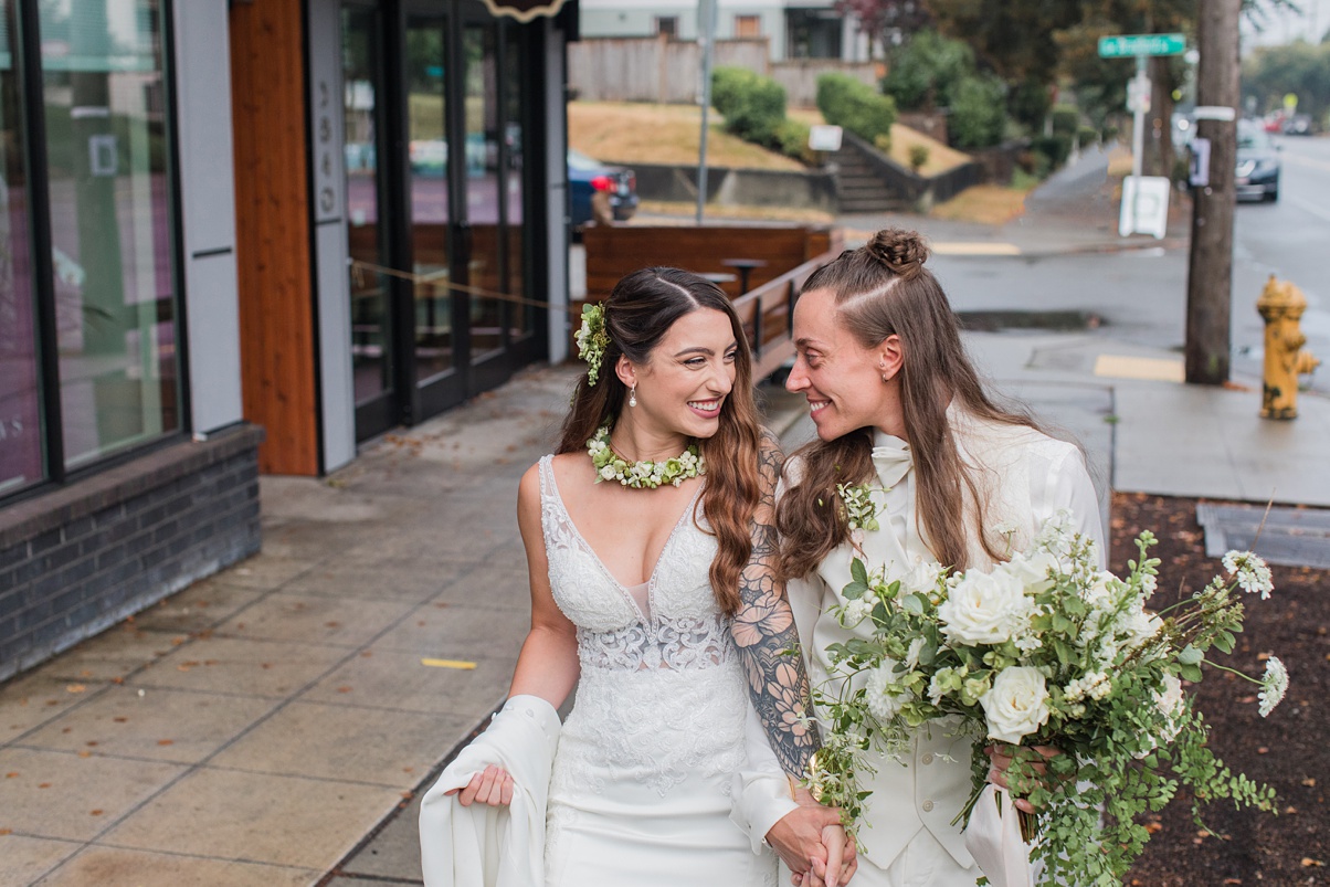 A couple embraces outside of their white wedding ceremony, just married