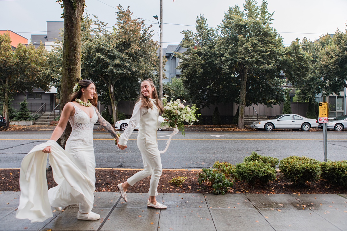 A lesbian couple celebrates their white wedding with a quick run down the sidewalk together