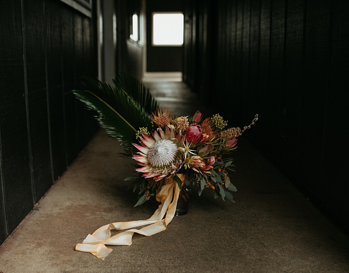 The tropical wedding flower bouquet sitting in a dark, dramatic shot