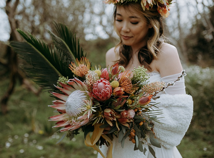 A bride holds her tropical wedding flower bouquet