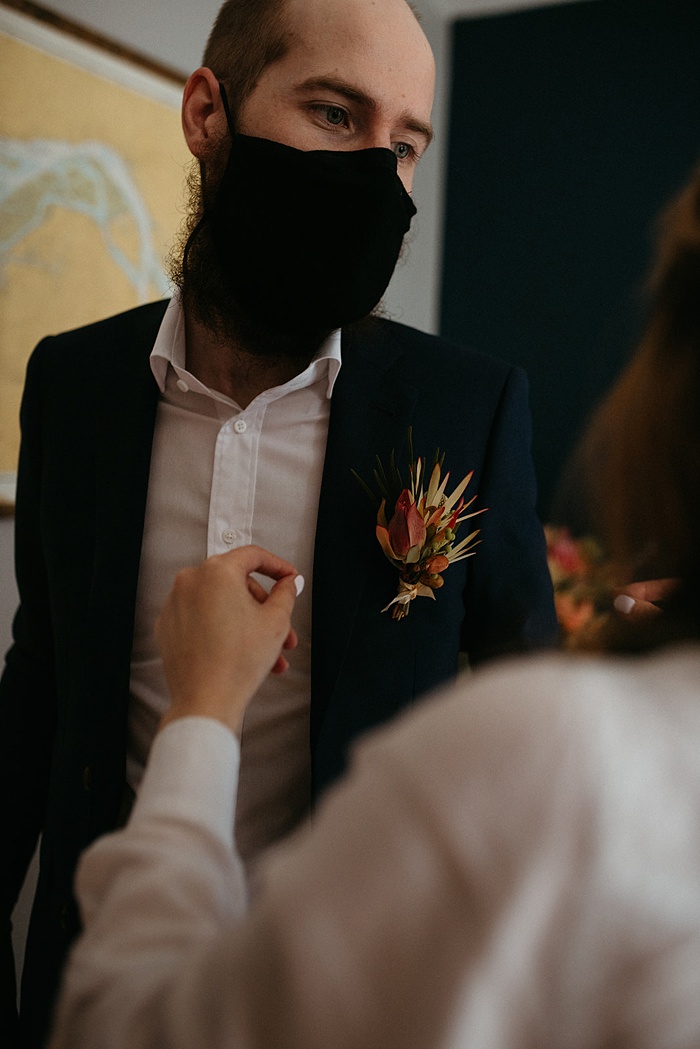 Mom pins a boutonniere on the groom