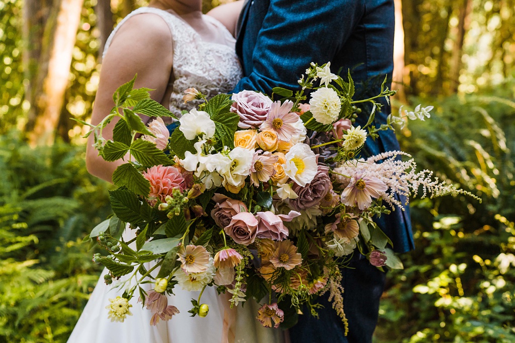 A closer look at the bridal bouquet full of poppies, roses, dahlias, and cosmos
