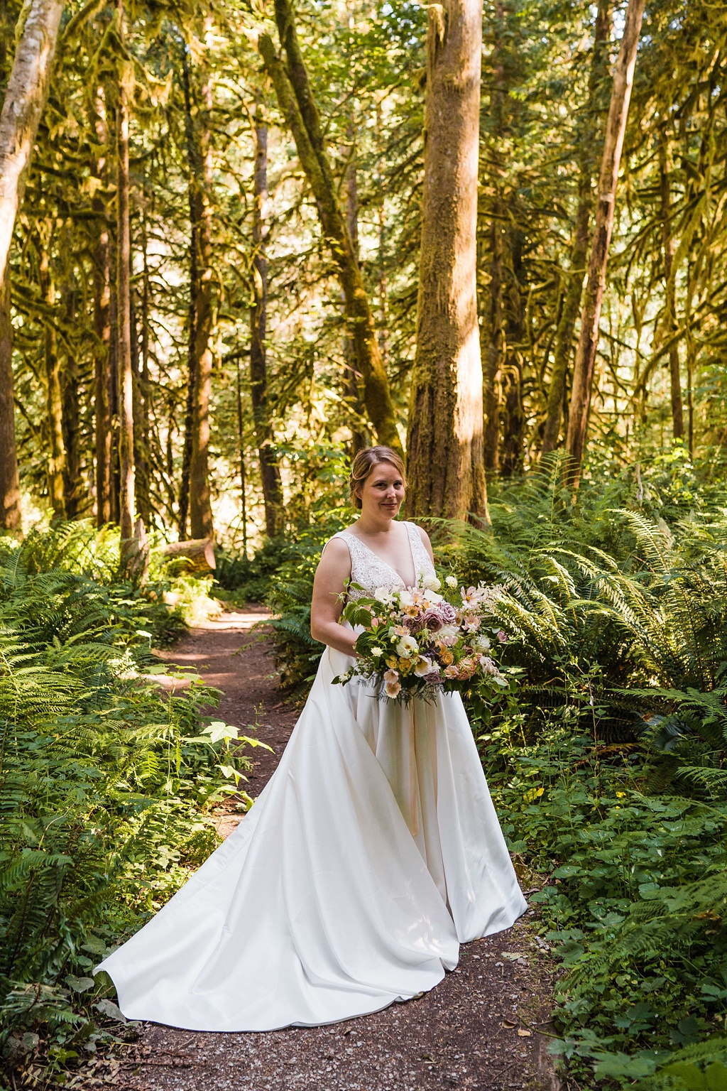 A bride holds her bouquet in the woods