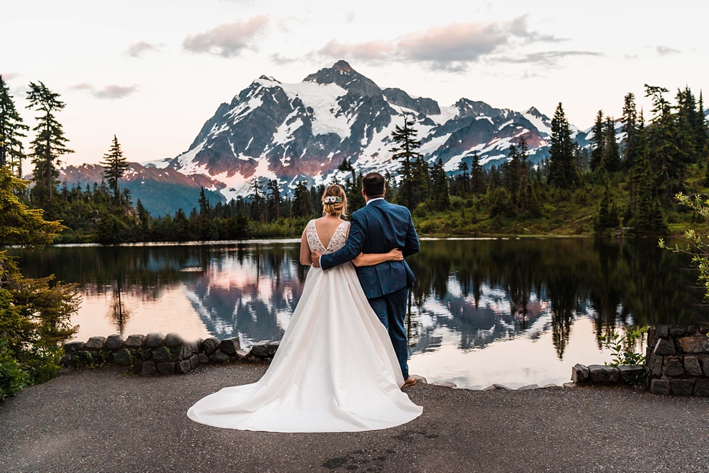 A couple embraces at sunset at an alpine lake