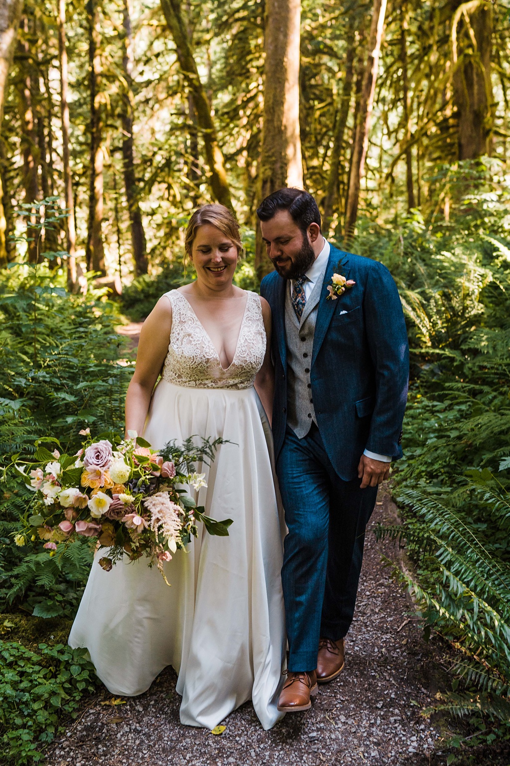 The couple walks in the woods holding the bouquet