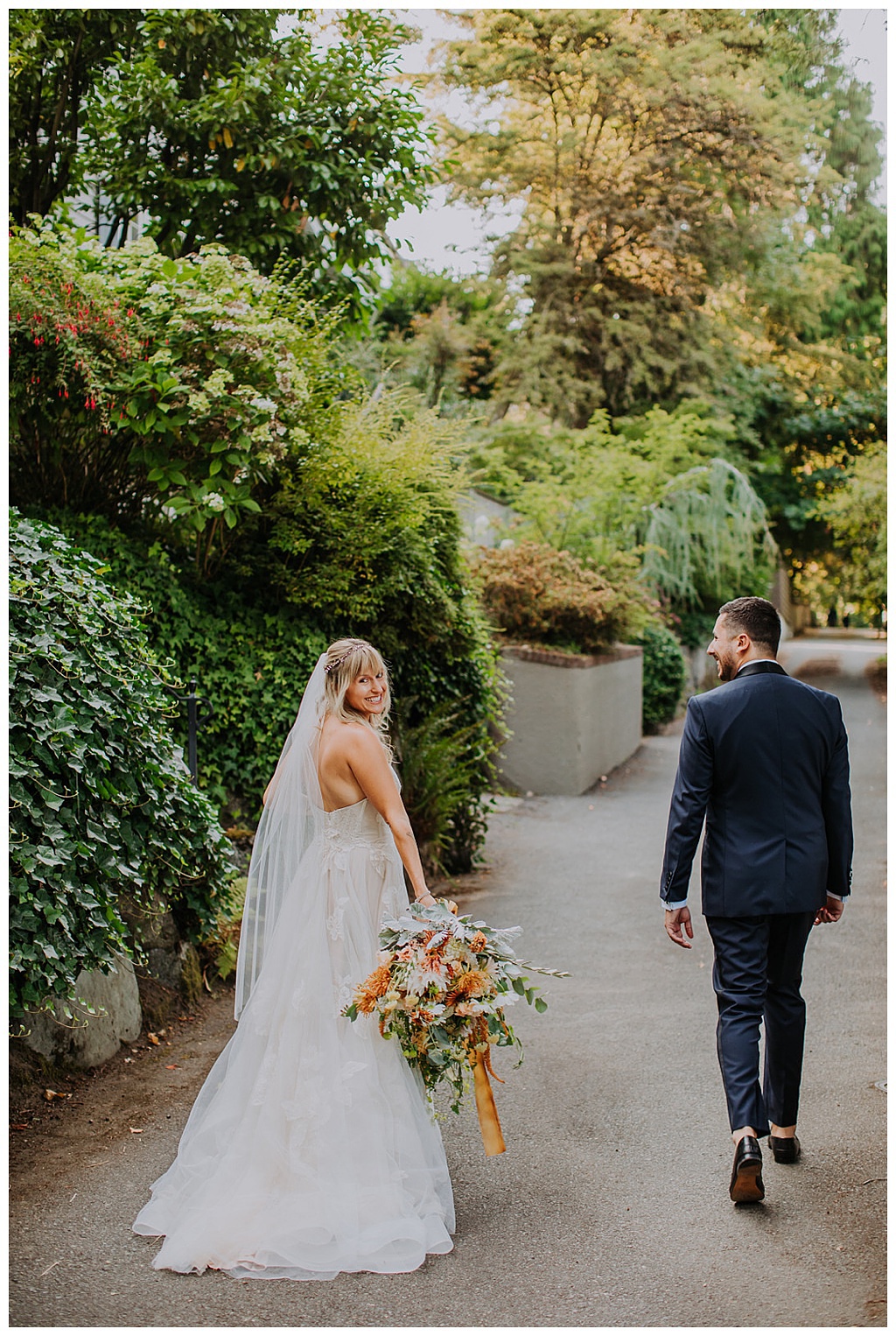 The couple walking holding the fall bridal bouquet