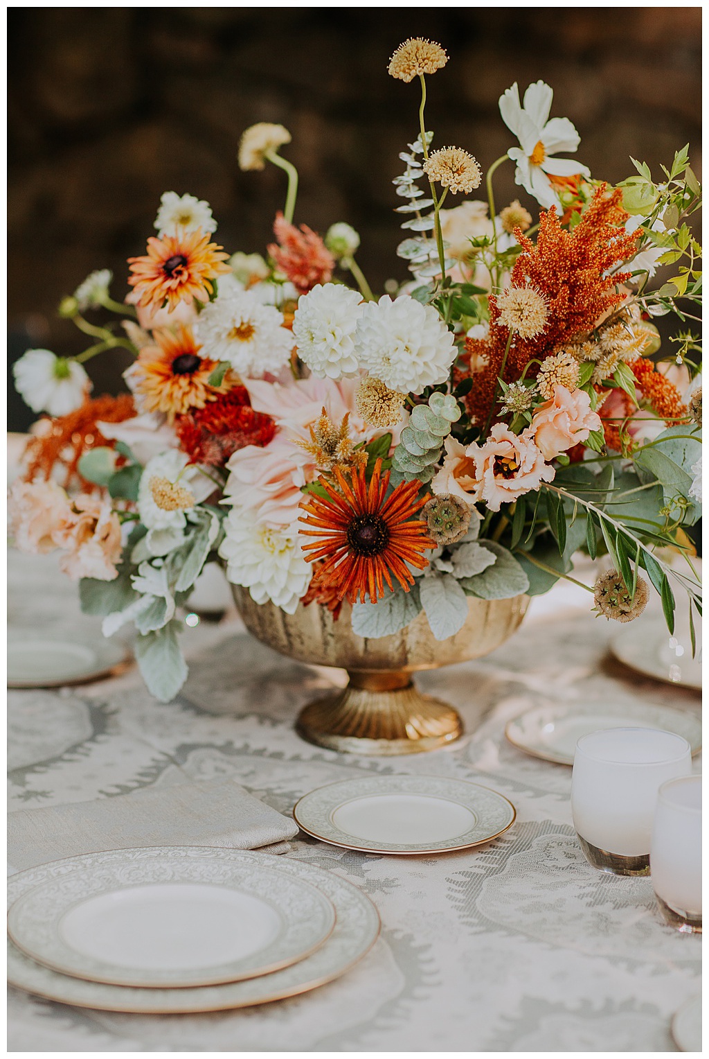 a low centerpiece with fall wedding flowers for the guest table