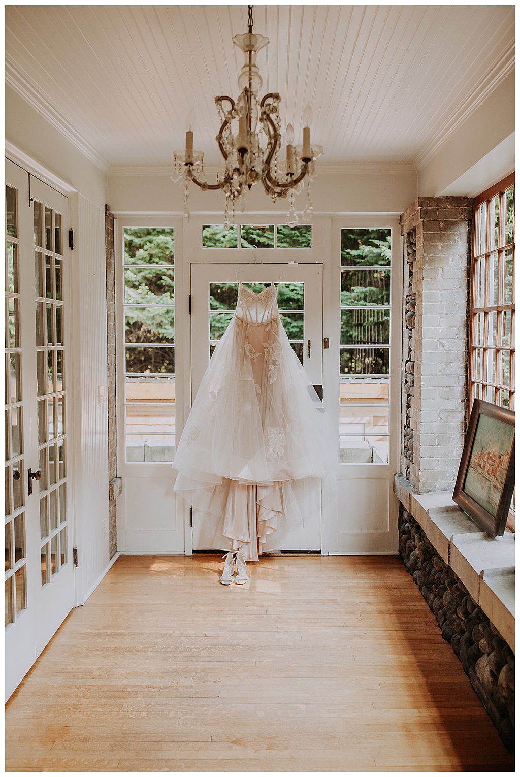 the bride's wedding dress hangs from a doorway