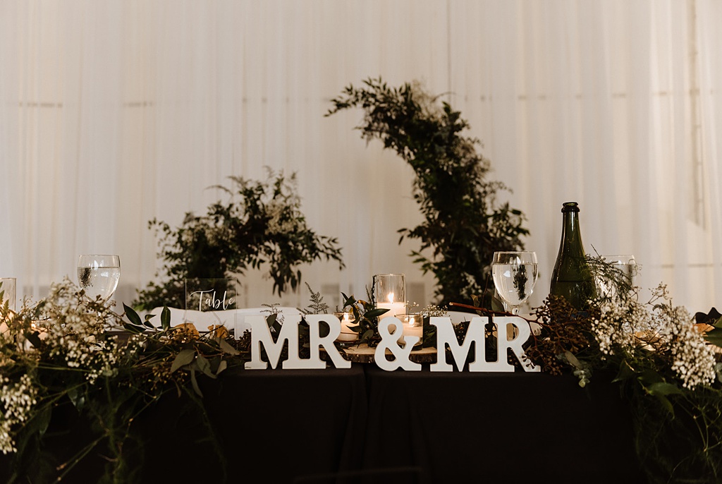 Head table decor with a MR + MR sign for the gay couple