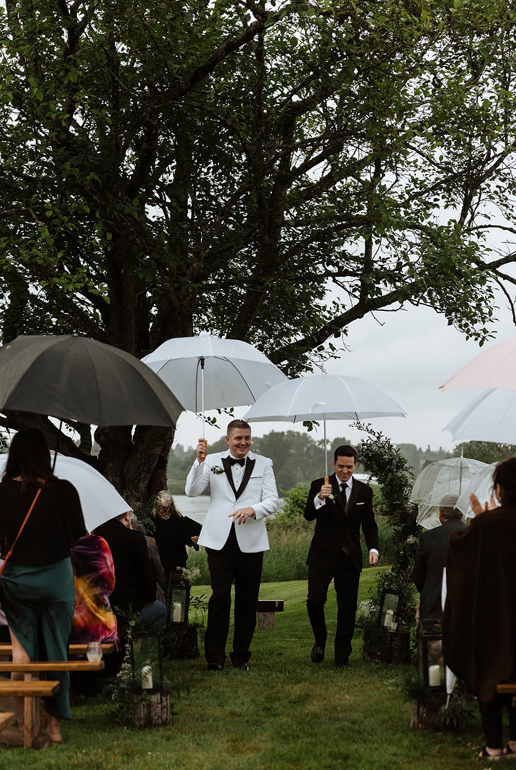 A gay couple leaving their wedding ceremony holding umbrellas