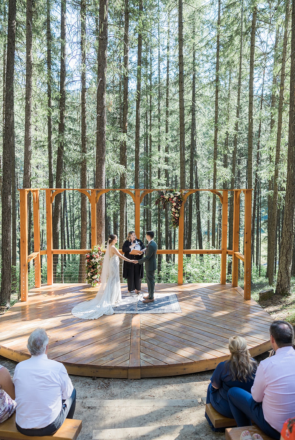 The tall pine trees and wedding florals provide a stunning ceremony backdrop for this Tierra Retreat Center wedding
