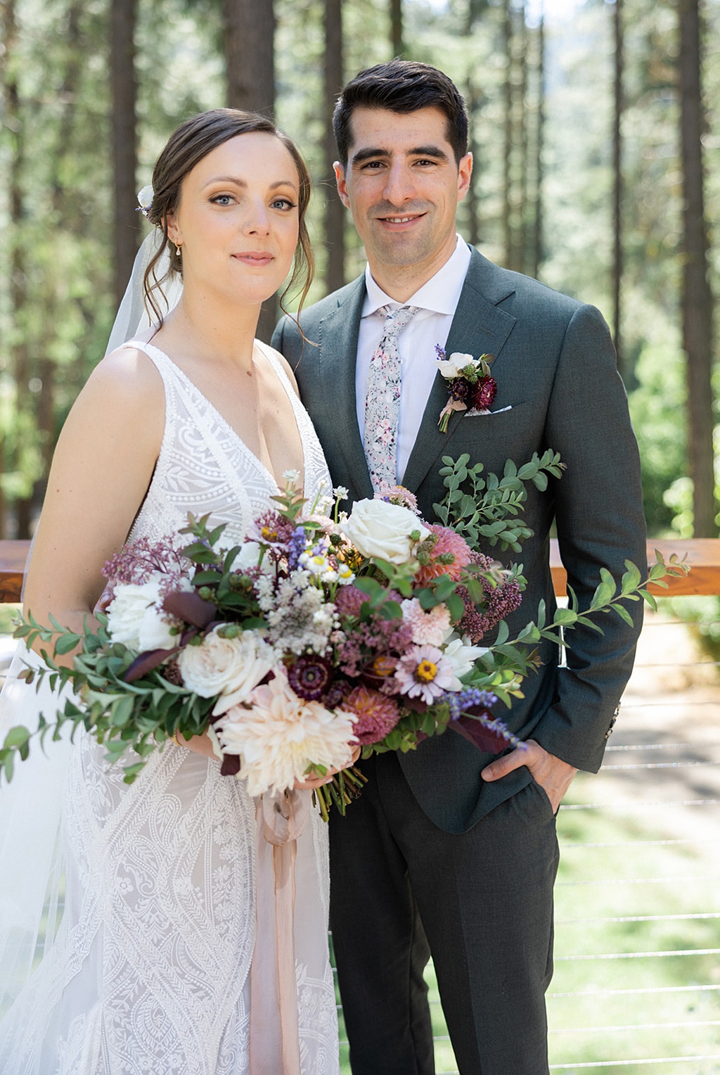 The bride and groom pose with the bridal bouquet at the ceremony