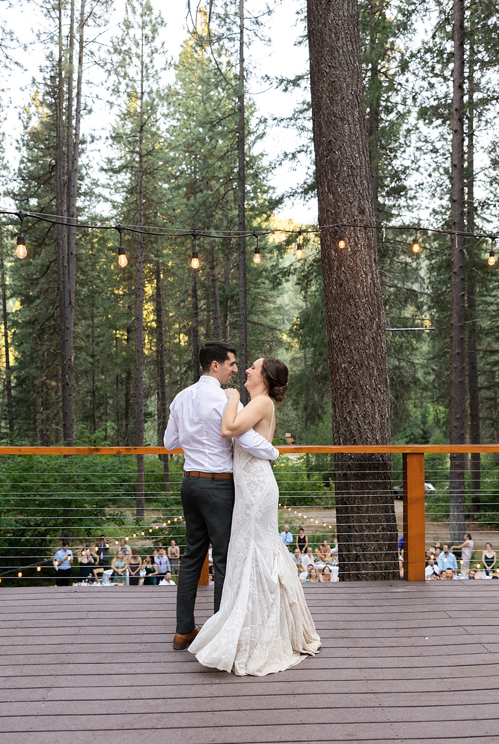 The first dance at the wedding reception, with pines in the background