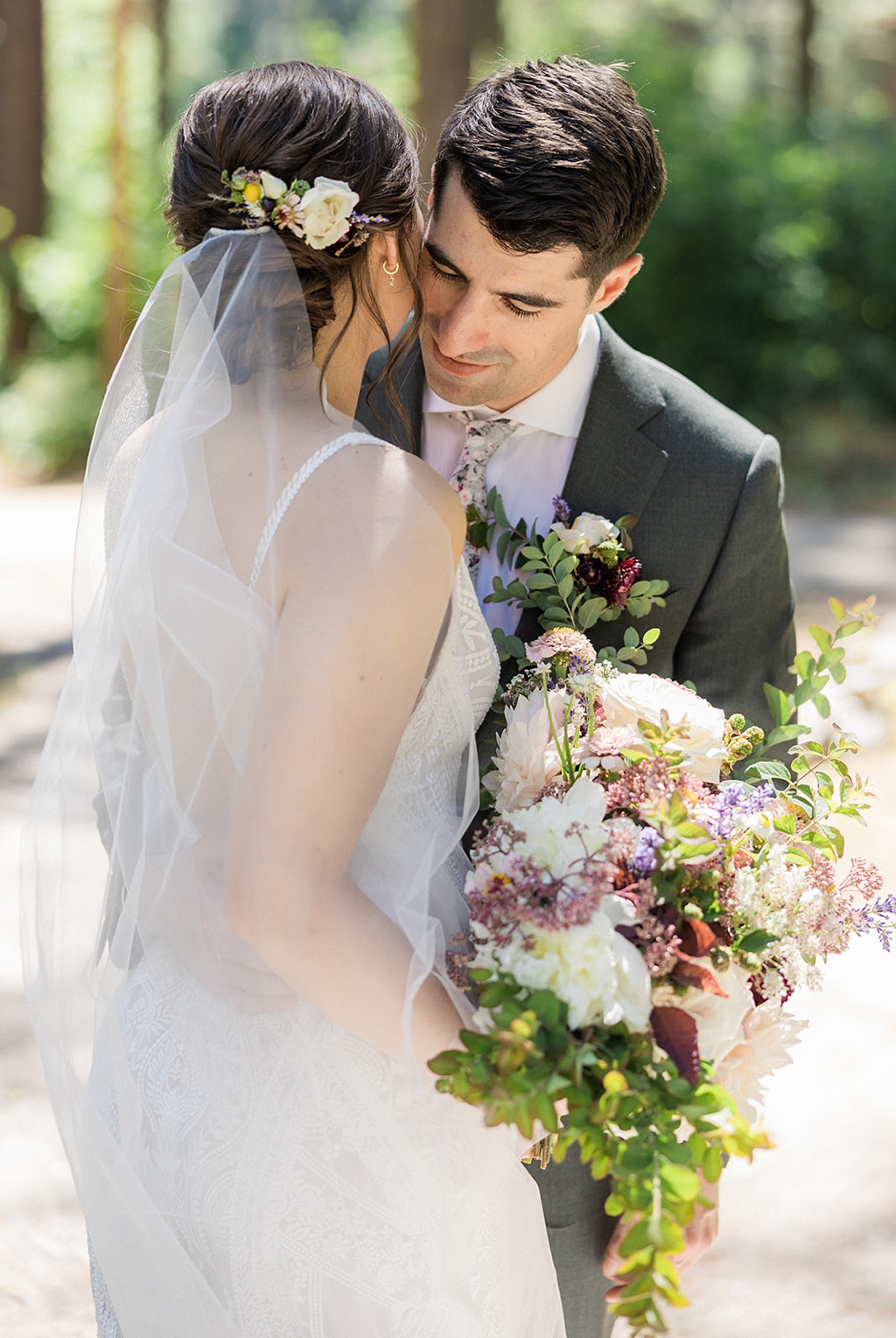The bride and groom embrace, showing off her hair flowers