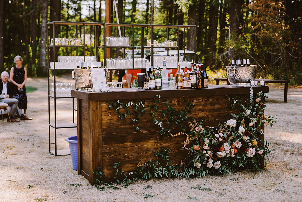 Summer wedding flowers on the bottom of a wooden bar