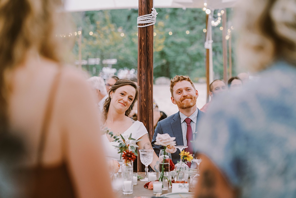 The head table with couple smiling at this summer wedding