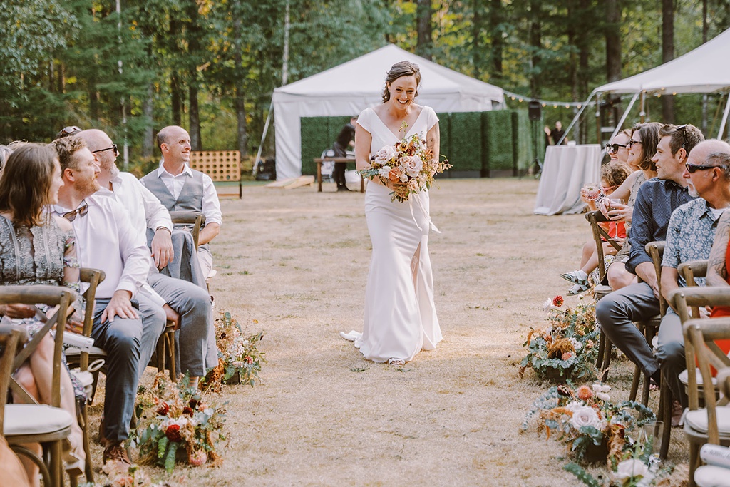The bride walks down her own aisle at this modern summer wedding